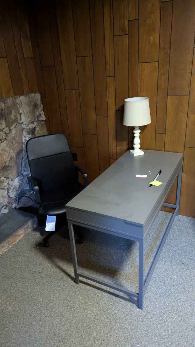 Grey office desk and black office chair ready for office furniture removal